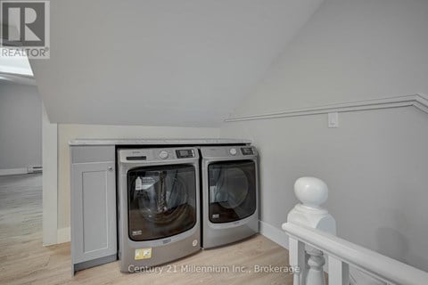 Two ovens in a kitchen with a white railing.