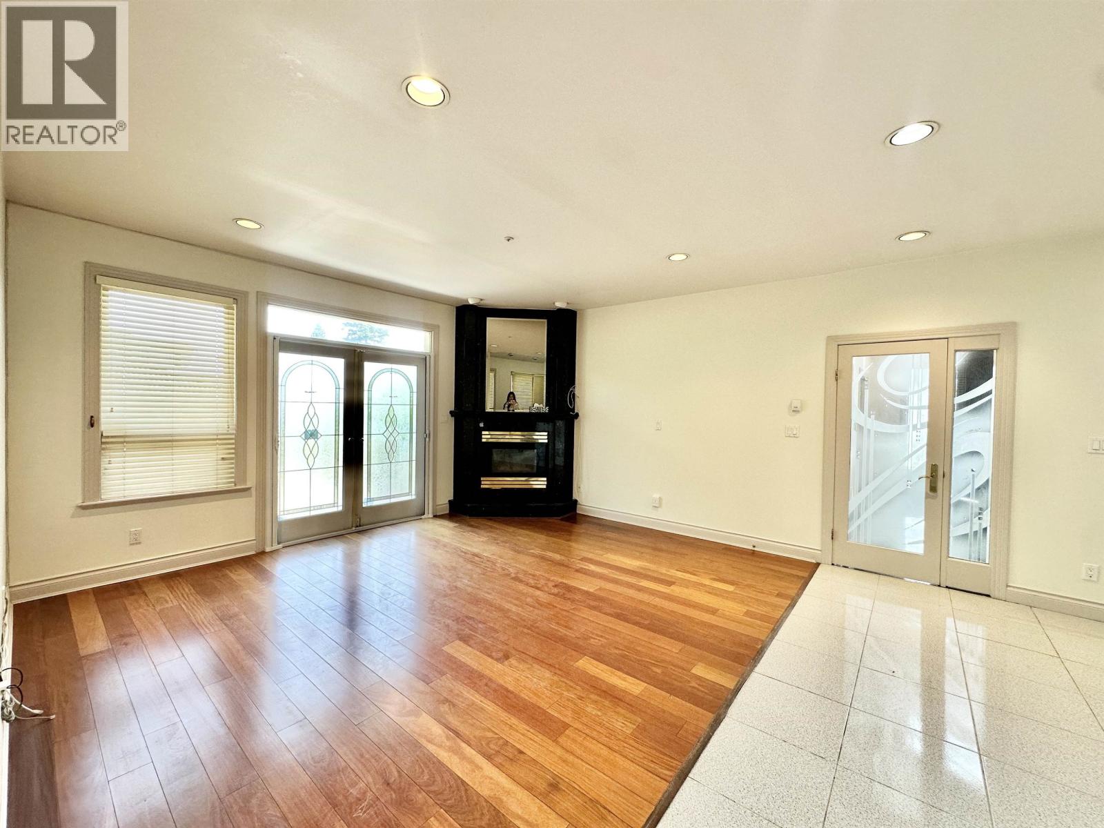 A spacious room with wooden floors and white walls.