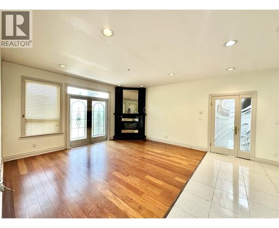 A spacious room with wooden floors and white walls.