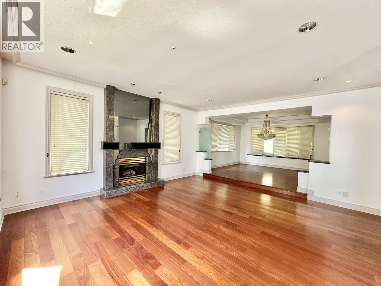 A spacious living room with hardwood floors and a fireplace.