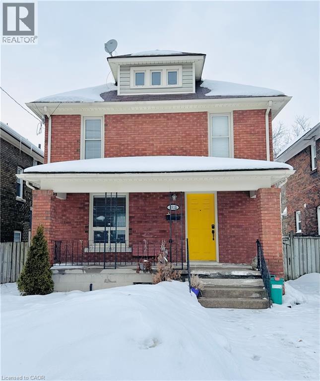 A red brick house with a white door and windows.