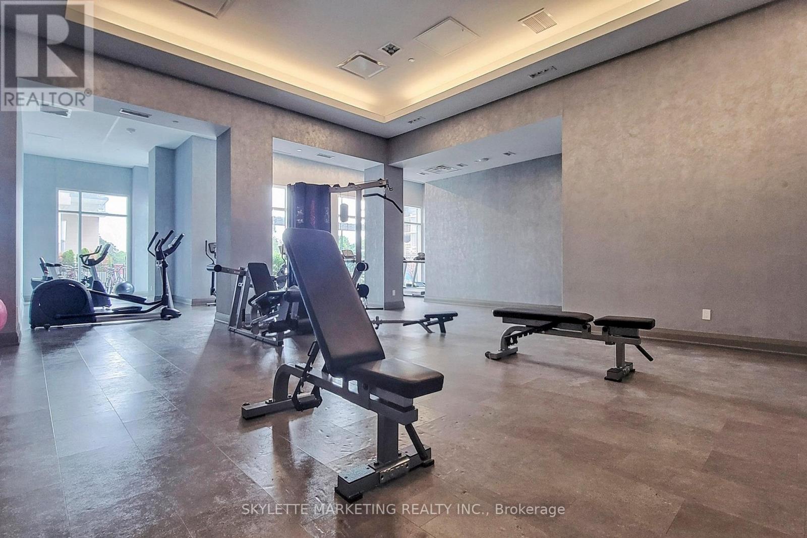 A gym with a row of benches and a row of exercise machines.