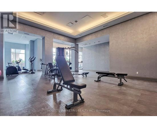 A gym with a row of benches and a row of exercise machines.
