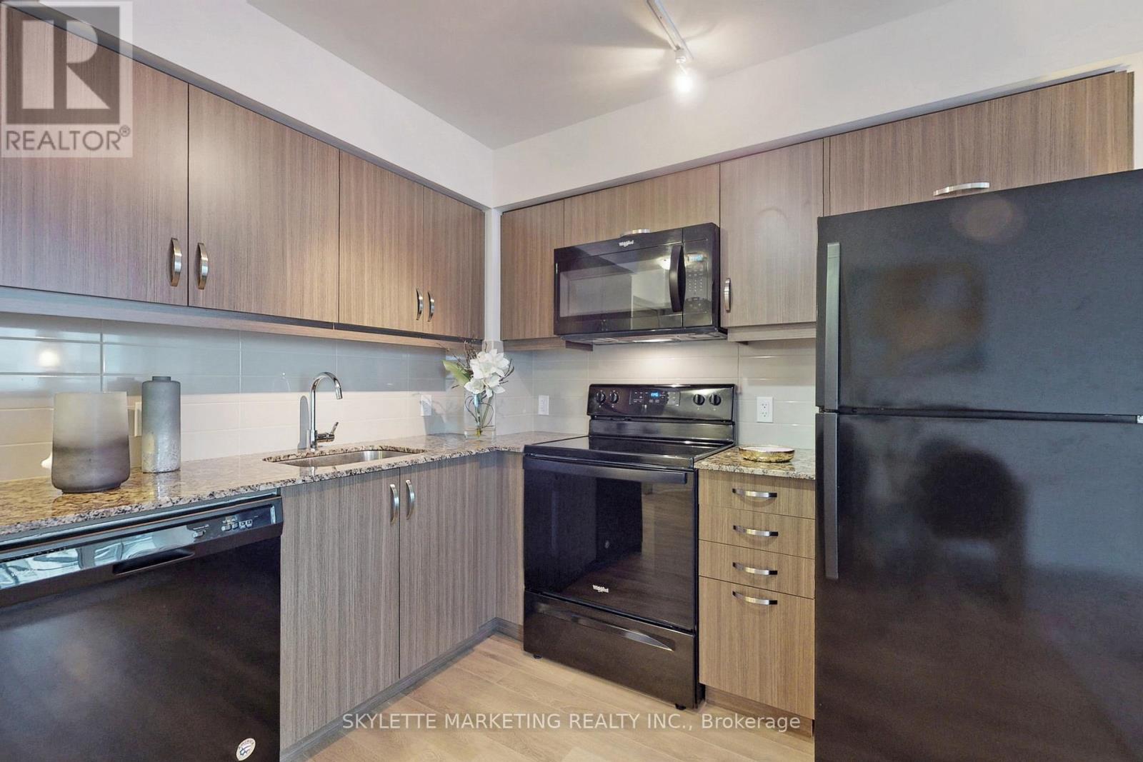 A modern kitchen with wooden cabinets and stainless steel appliances.