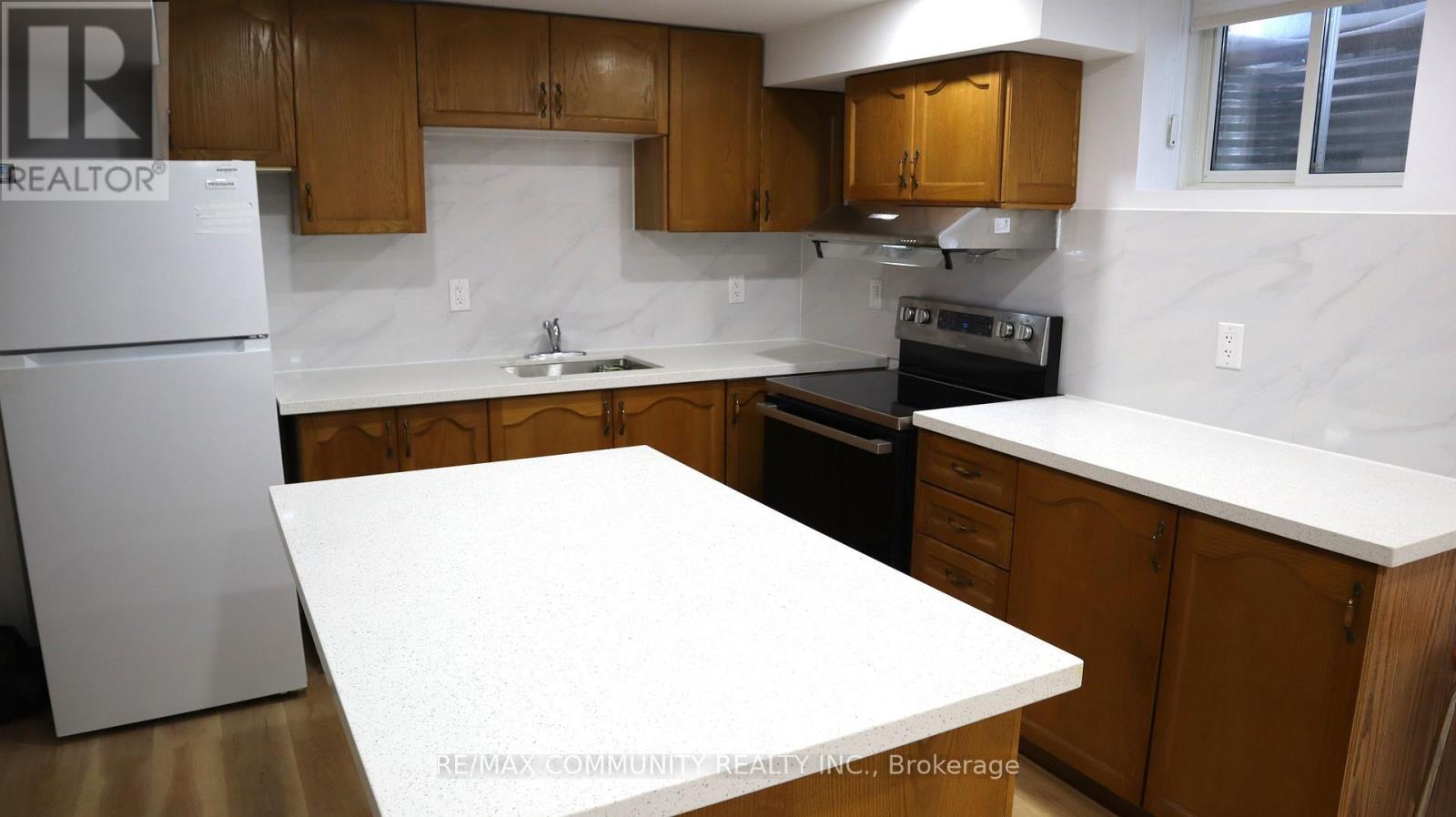 A kitchen with a white fridge and wooden cabinets.