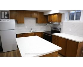 A kitchen with a white fridge and wooden cabinets.