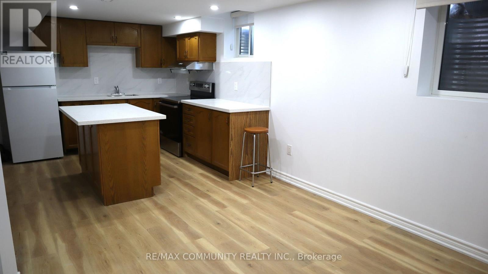 A kitchen with wooden floors and white walls.