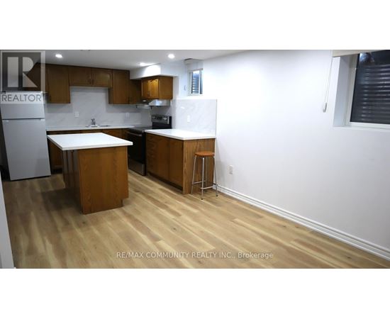 A kitchen with wooden floors and white walls.