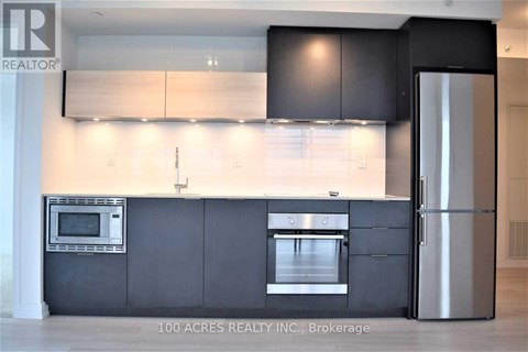 A modern kitchen with a stainless steel refrigerator and microwave.