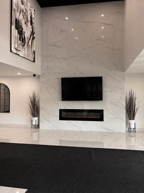 A modern living room with a fireplace and a large painting on the wall.