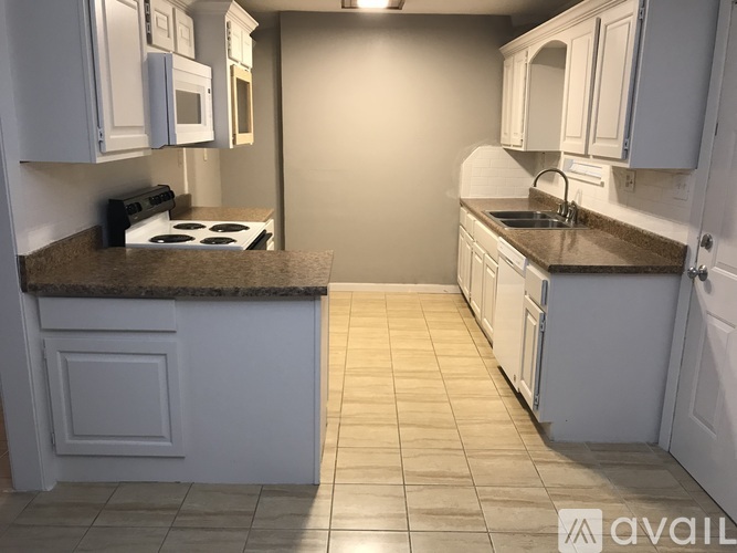 A kitchen with white cabinets and a granite countertop.