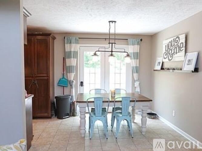 A dining room with a table and chairs.