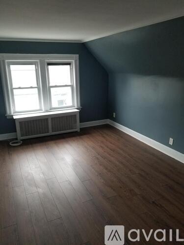 A room with a window and a radiator on the floor.