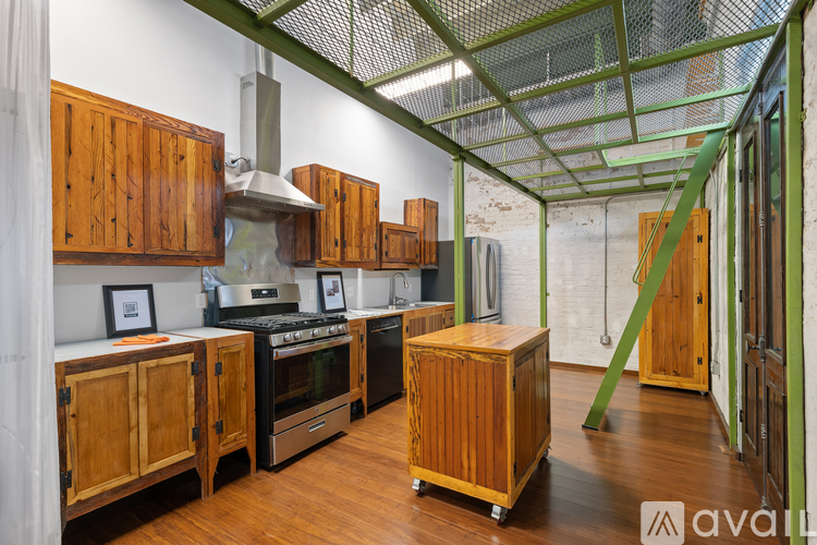 A kitchen with wooden cabinets and a green metal structure.