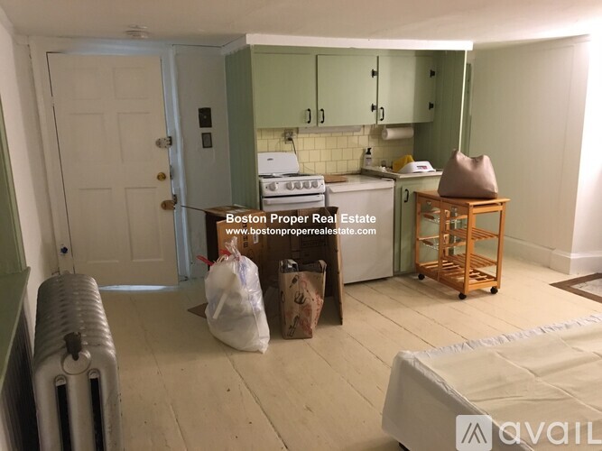 A room with a white door and a green wall with a sign that says Boston Proper Real Estate.