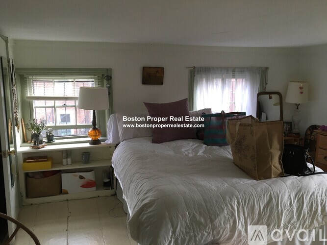 A bedroom with a bed, window, and a lamp.