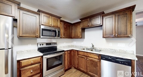 A kitchen with wooden cabinets and stainless steel appliances.