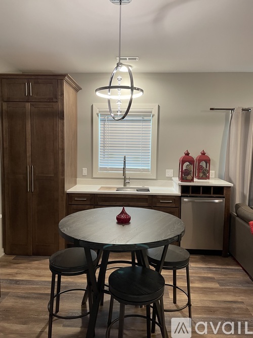 A kitchen with a table and chairs in the foreground and a refrigerator in the background.