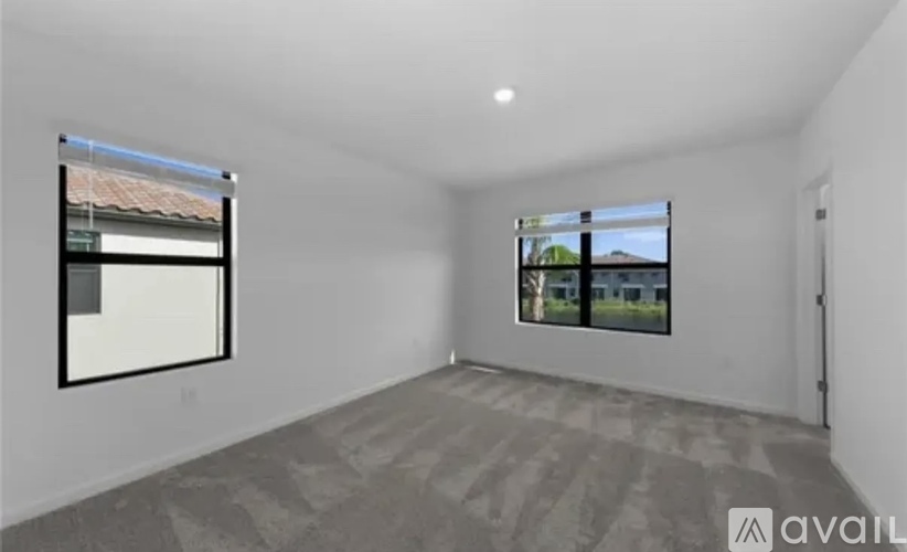 A spacious room with a large window and a view of a building outside.