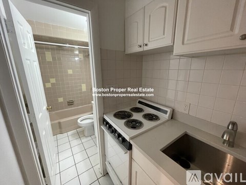 A kitchen with a stove top oven and a sink.