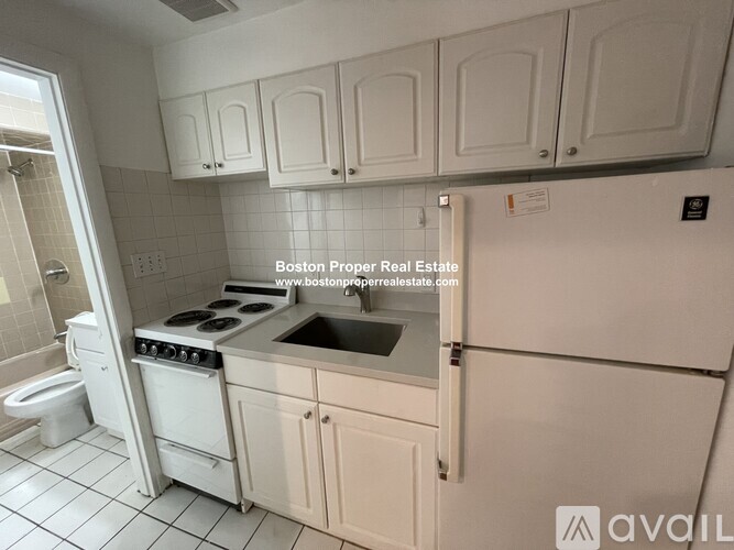 A kitchen with white appliances and cabinets is available for rent.