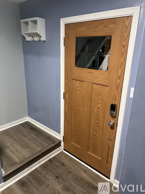 A wooden door with a glass window and a handle.