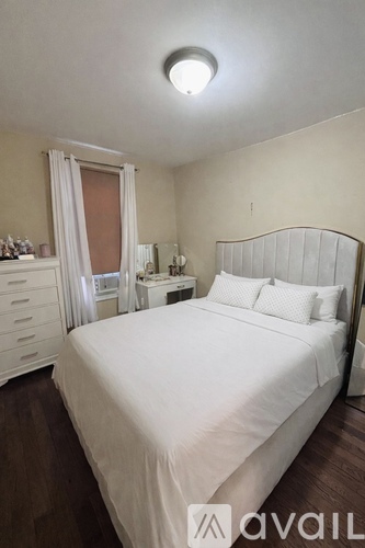 A bedroom with a large bed and a dresser with a mirror.