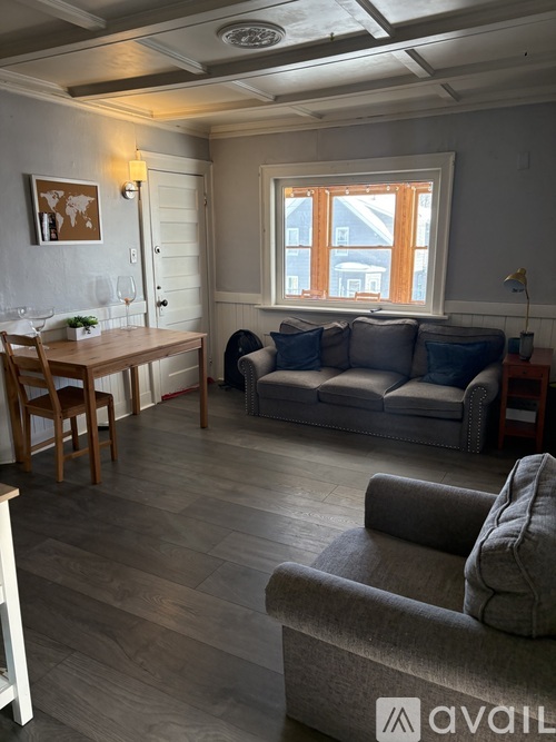A living room with a grey couch and a wooden table.
