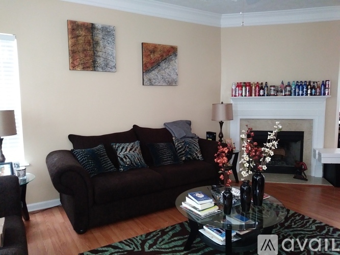 A living room with a brown couch and a fireplace.
