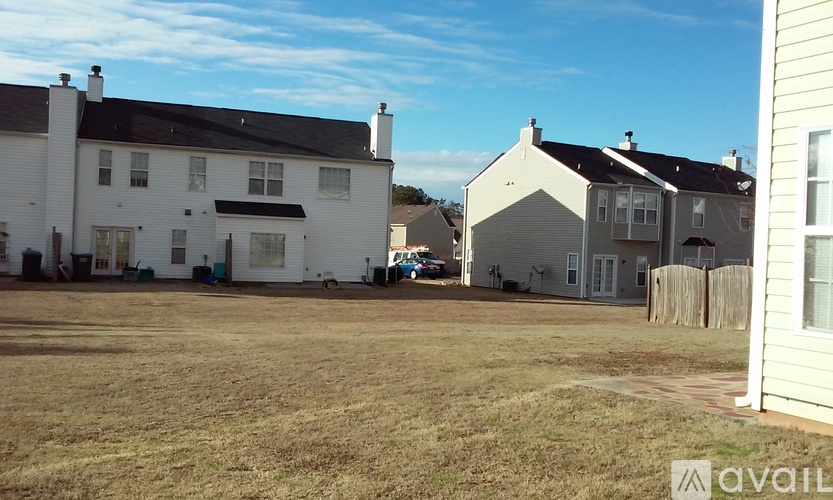 A grassy field with two houses in the background.
