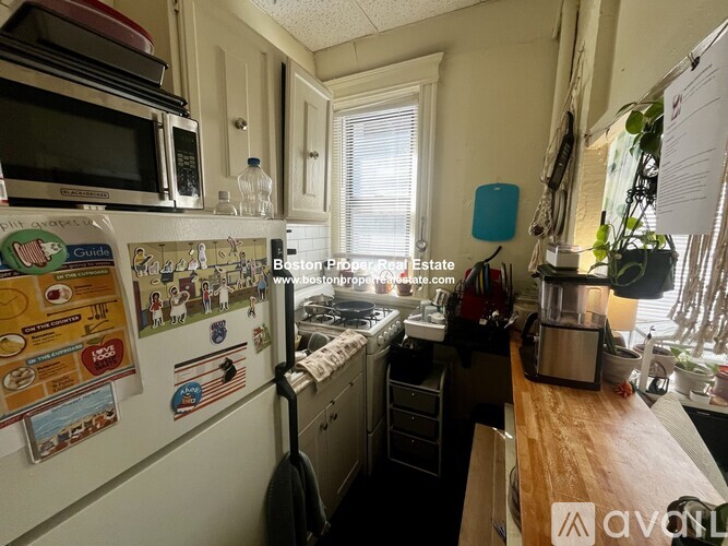 A kitchen with a white fridge and a wooden counter top.