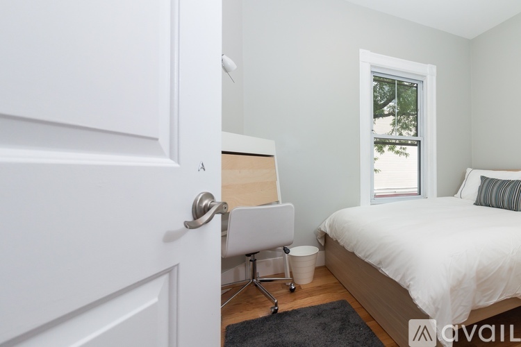 A bedroom with a bed, chair, and window.