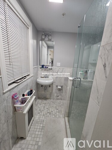A bathroom with a glass shower door and a white toilet.