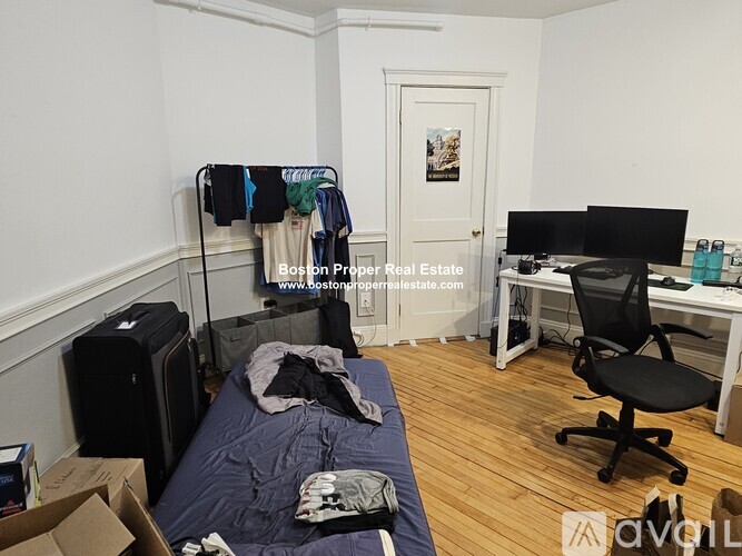 A bedroom with a bed, desk, and chair.