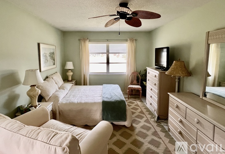 A bedroom with a bed, dresser, and chair.