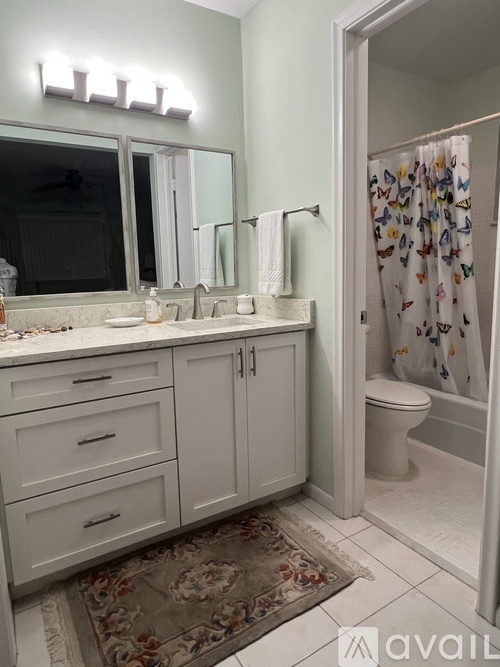 A bathroom with a white toilet and a shower curtain with a floral pattern.