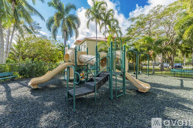 A playground with a slide and a green and yellow play structure.