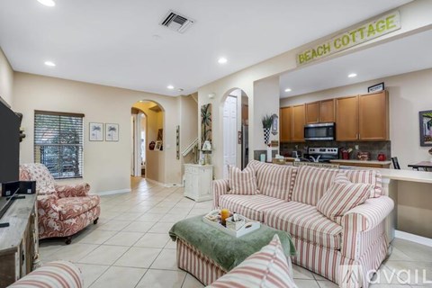 A living room with a striped couch and a television.