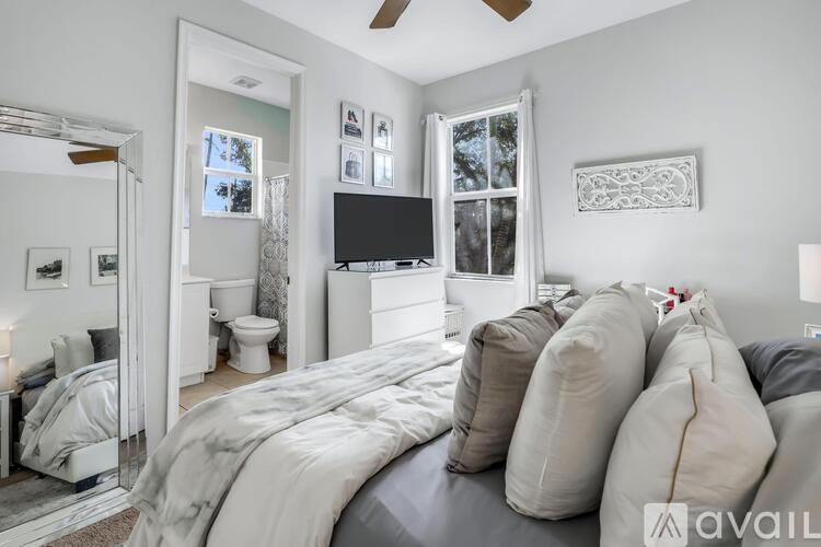 A bedroom with a large bed and a flat screen TV mounted on the wall.