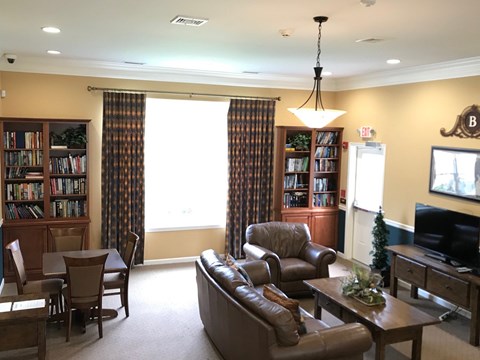 A living room with a brown leather couch and a wooden coffee table.