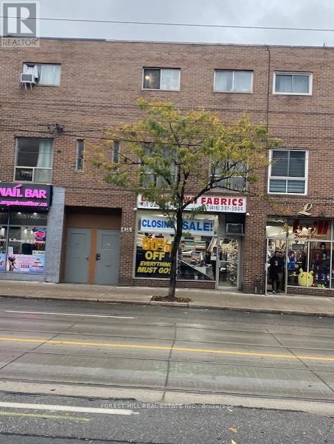 A tree in front of a building with a sign that says "Closing Sale!".