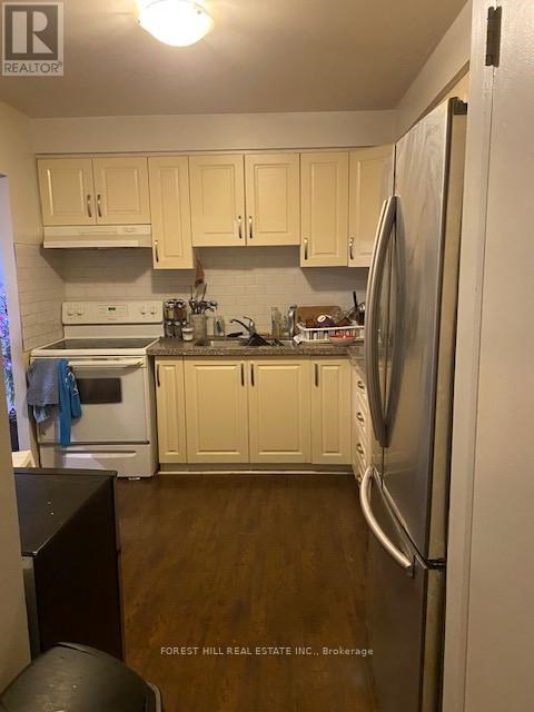 A kitchen with wooden cabinets and a white fridge.