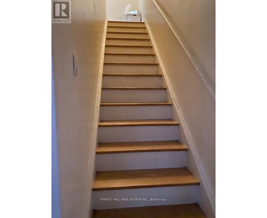 A staircase with wooden steps and white walls.