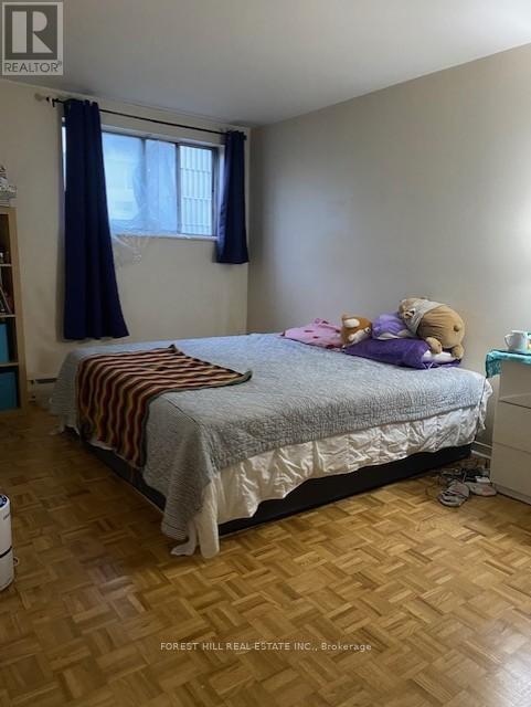A bedroom with a bed, a window with curtains, and a teddy bear on the bed.