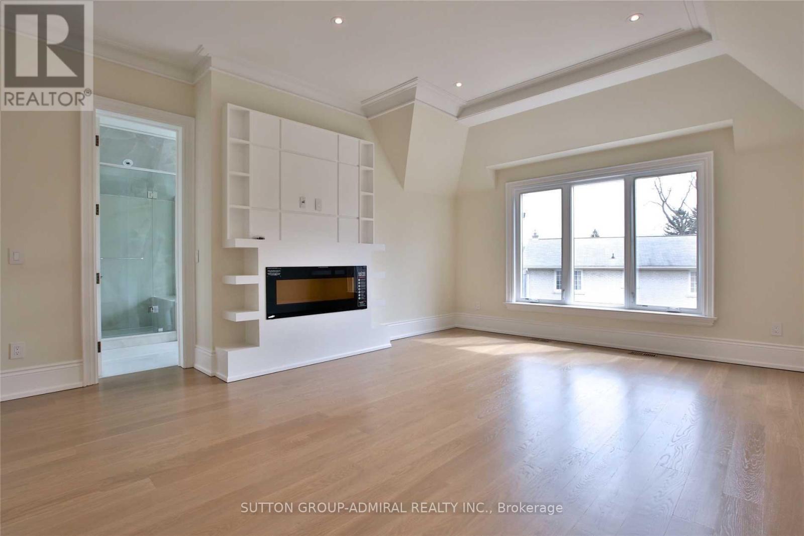 A spacious room with a fireplace and large windows.