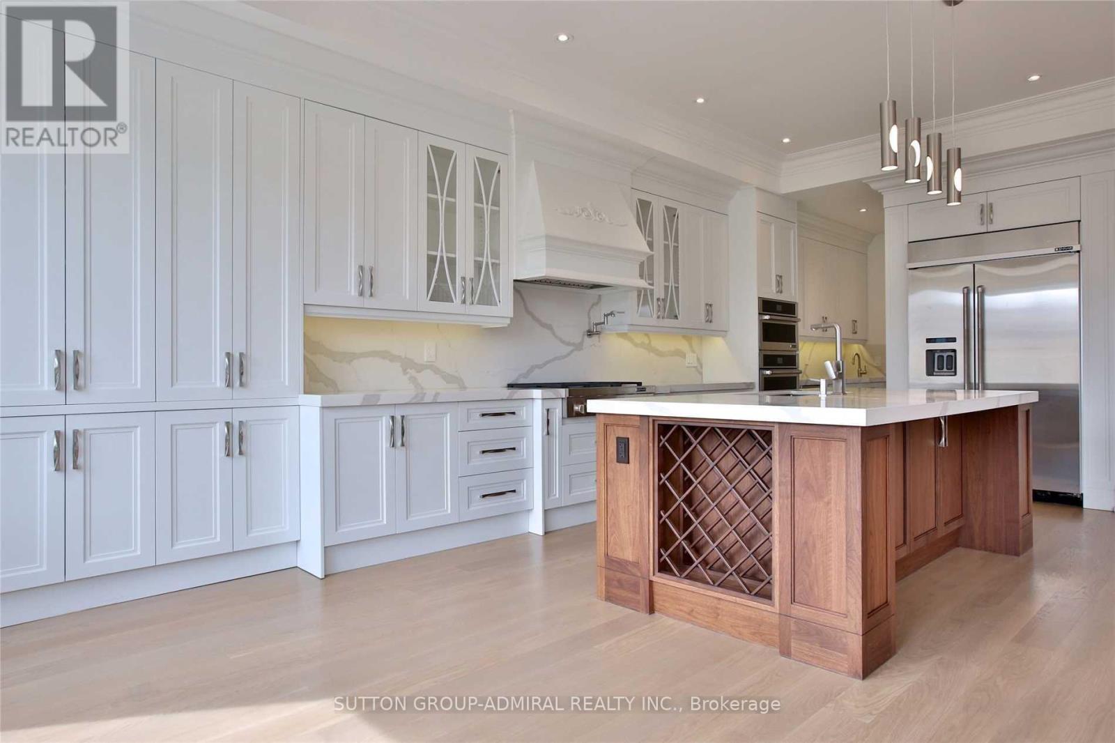 A kitchen with white cabinets and a wooden island.