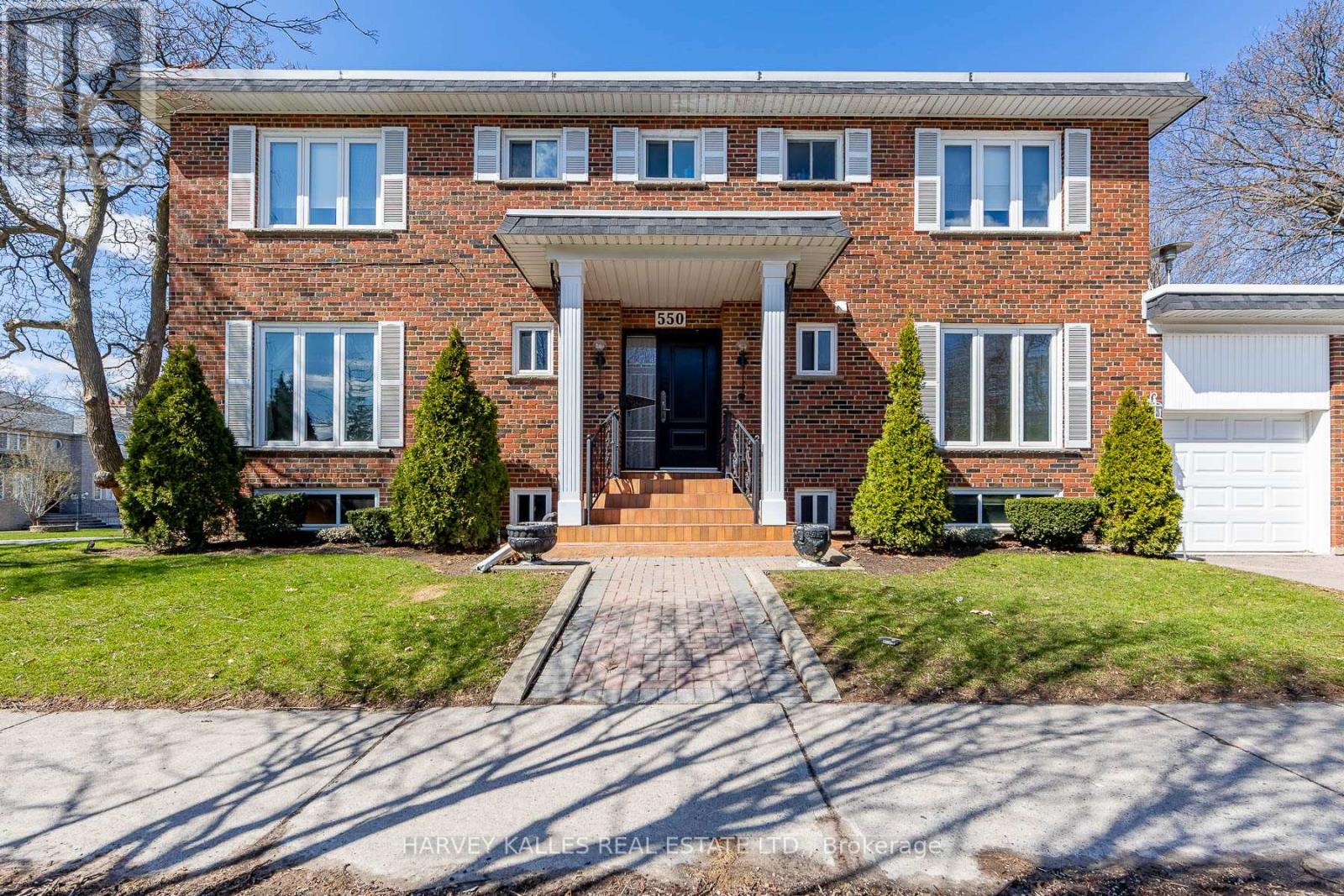 A brick house with a front yard and a driveway.