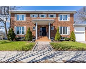 A brick house with a front yard and a driveway.