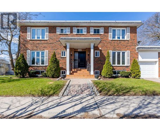 A brick house with a front yard and a driveway.