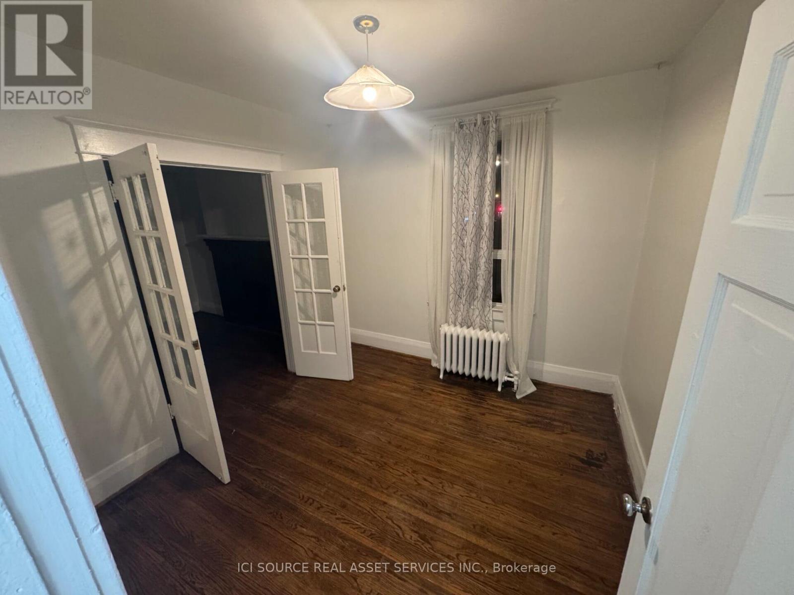 A room with a white door and a white radiator.